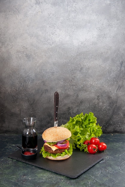 회색 표면에 줄기와 검은 트레이 소스 케첩 토마토에 맛있는 고기 샌드위치와 피망에 칼의 세로보기