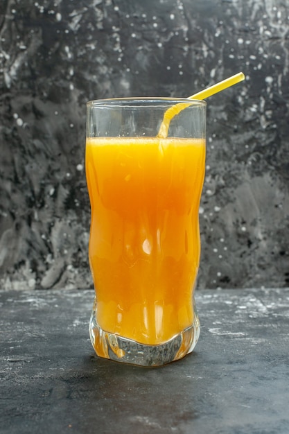 Vertical view of natural organic fresh juice in a glass on gray background