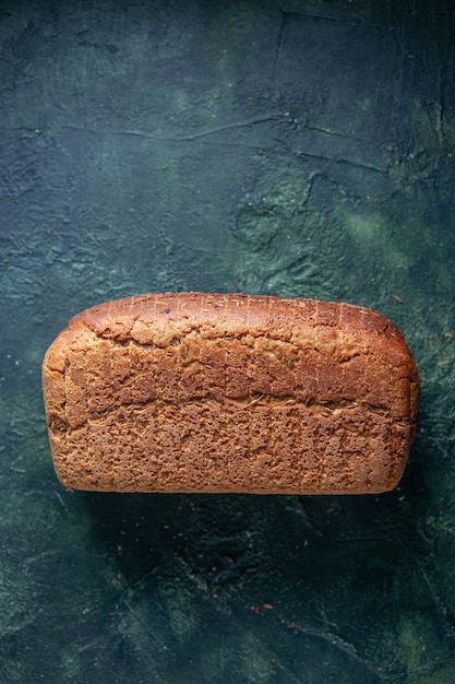 Foto gratuita vista verticale di fette di pane nero confezionate su sfondo invecchiato di colori misti con spazio libero