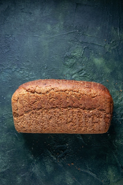 Free photo vertical view of packed black bread slices on mixed colors distressed background with free space