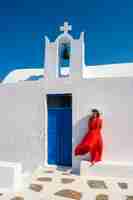 Free photo vertical view of red dressed woman in oia