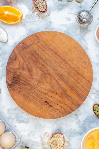 Vertical view of round board and ingredients for the healthy food set on stained white background