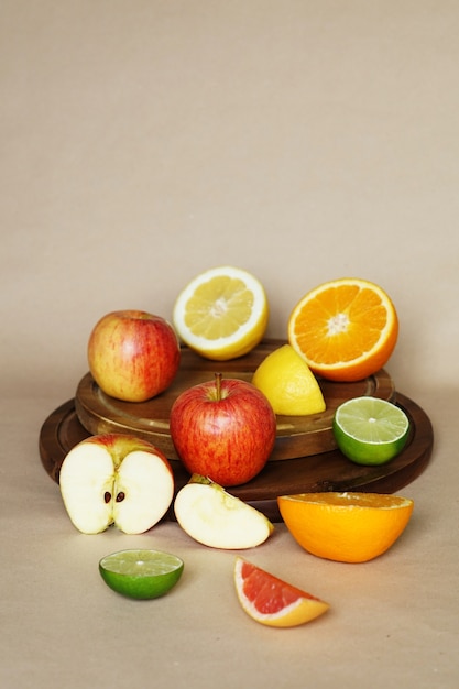 Vertical view of several vegetables and fruits on a circular wooden object