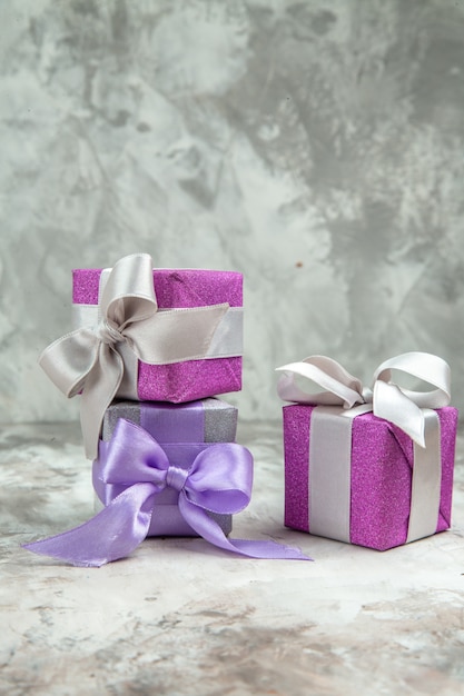 Vertical view of three xsmas gifts for family members on ice background