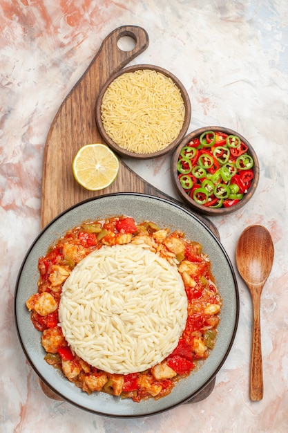 Foto gratuita vista verticale del pollo al pomodoro con riso bianco