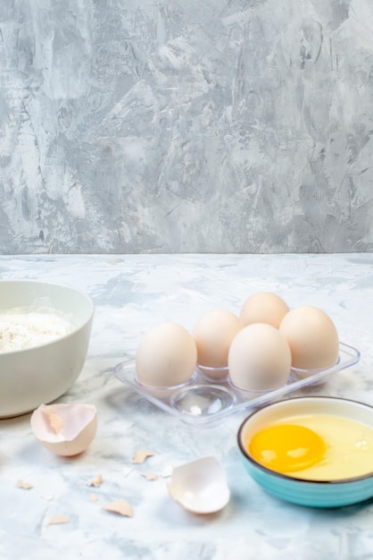 그릇에 든 흰 밀가루와 스테인리스 요리 도구 계란 레몬 슬라이스의 수직 보기