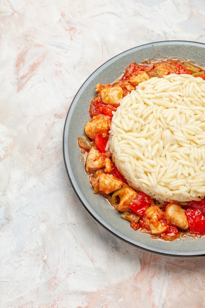 Vertical view of white rice meal with chicken and tomato