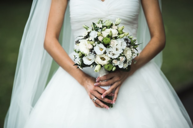 Very beautiful wedding bouquet in hands of the bride