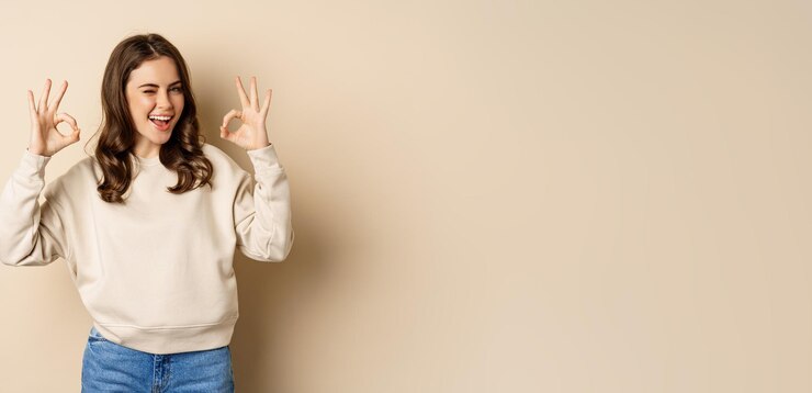 Free Photo very good nice work cheerful young woman agrees shows okay ok praise recommending smth standing over