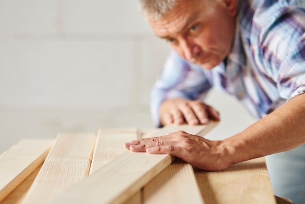 Very hard working man meausers another wooden planks