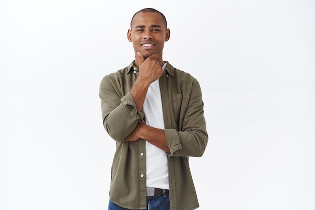 Free photo very interesting portrait of intrigued africanamerican man touch chin squinting and smiling nod in approval see something satisfying positive feedback like product feel pleased