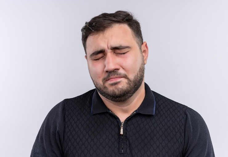 無料Photo 目を閉じて黒いシャツを着た非常に悲しい若いひげを生やした男