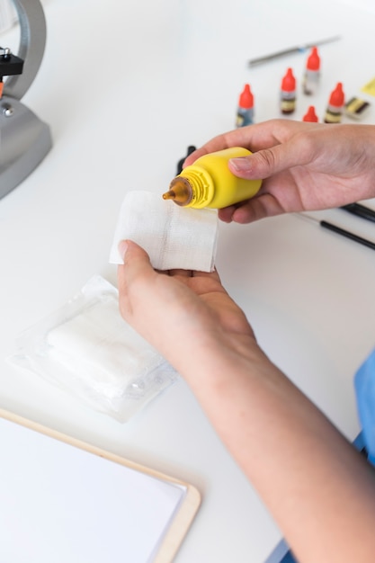 Veterinarian pouring chemical on medical gauze