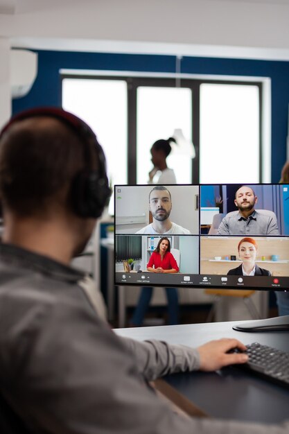 Video editor director talking with creative team in web online meeting on video call editing client work, getting feedback on commercial movie using post production software on pc in creative office