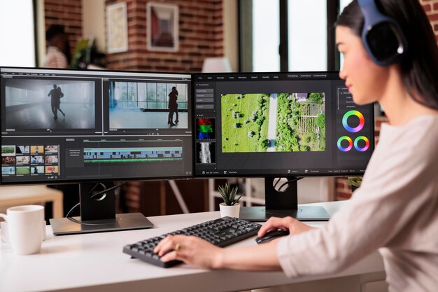 컴퓨터의 포스트 프로덕션 소프트웨어로 오디오 필름 몽타주를 편집하는 비디오 편집기. 집에서 컬러 그레이딩과 시각 효과 또는 음향 효과를 사용하여 영화 푸티지 편집 작업을 하는 비디오그래퍼.