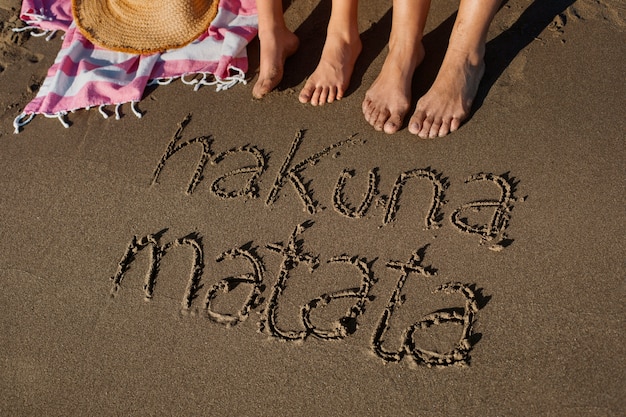 Foto gratuita vista della sabbia della spiaggia in estate con un messaggio scritto su di essa