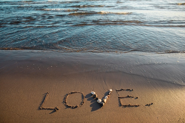 Foto gratuita vista della sabbia della spiaggia in estate con un messaggio scritto su di essa