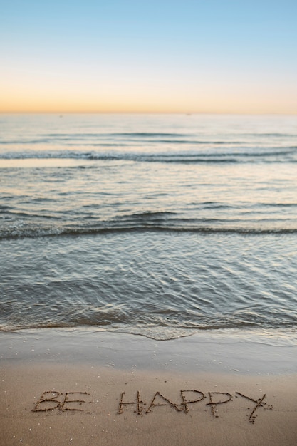 Вид пляжного песка в летнее время с записанным в нем сообщением