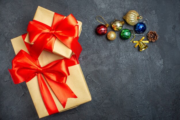 Above view of beautiful gifts with bow-shaped ribbon decoration accessories on a dark background