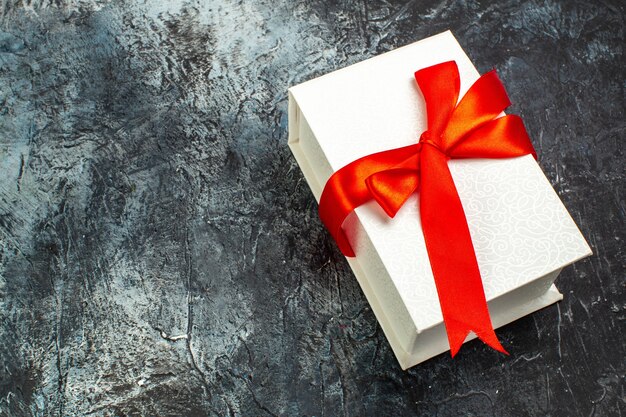 Above view of beautifully packaged gift boxes tied with red ribbon on the right side on dark