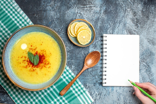 Above view of a blue pot with tasty soup served with mint and pepper