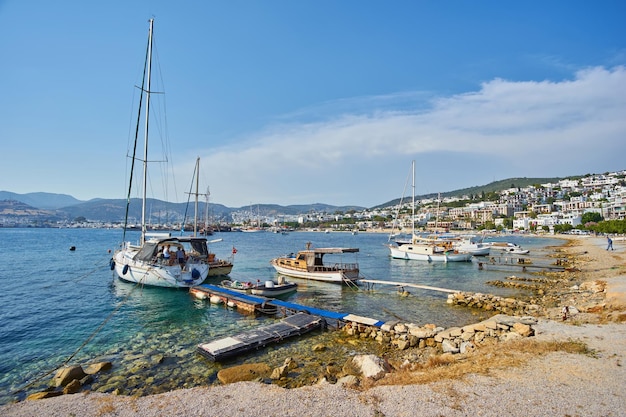 Foto gratuita vista della spiaggia di bodrum mar egeo tradizionali case bianche fiori marina barche a vela