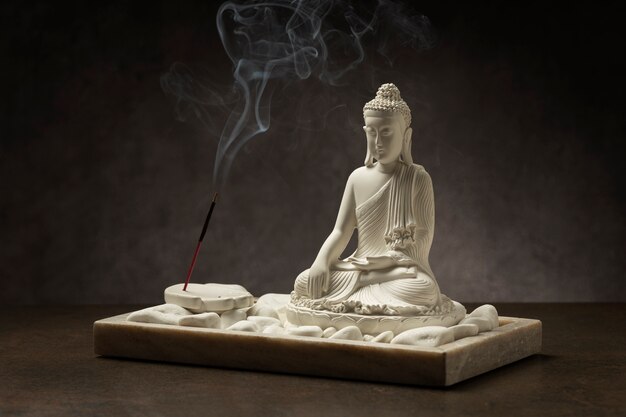 View of buddha statuette with incense