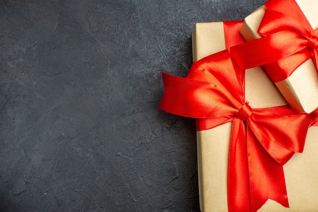 Above view of Christmas background with beautiful gifts with bow-shaped ribbon on a dark background