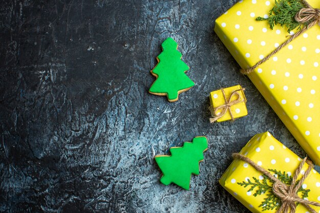 어두운 배경에 노란색 선물 상자와 쿠키가 있는 크리스마스 배경 보기 위