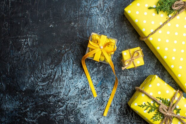 어두운 배경에 가족 구성원을 위한 노란색 선물 상자가 있는 크리스마스 배경 보기 위