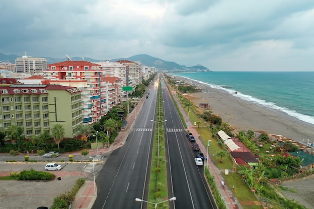 View of the city buildings near the sea line of azure sea water. Beach. Modern houses and hotels by the sea. Turkey