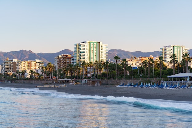 View of the city buildings near the sea line of azure sea water. Beach. Modern houses and hotels by the sea. Turkey