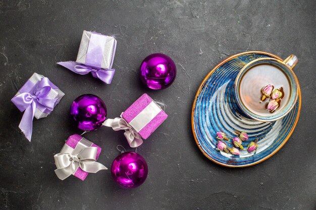 Above view of colorful gifts and decoration accessories a cup of black tea on dark background