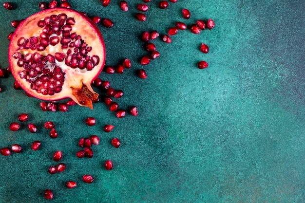  view  copy space chopped half pomegranate with peeled on a green table