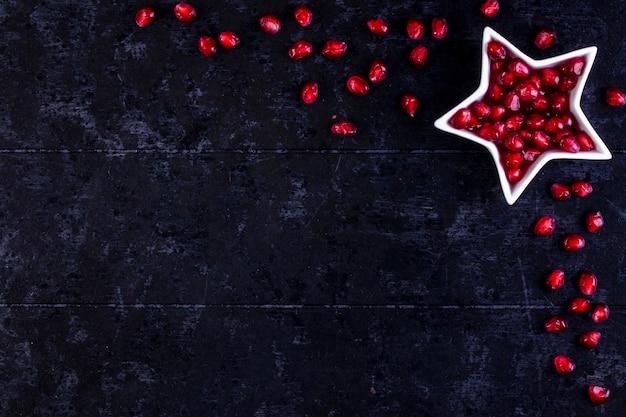 view  copy space peeled pomegranate in the shape of a star  on a black table