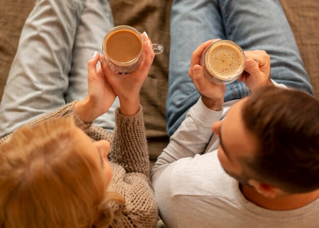 Free photo above view couple holding drinks