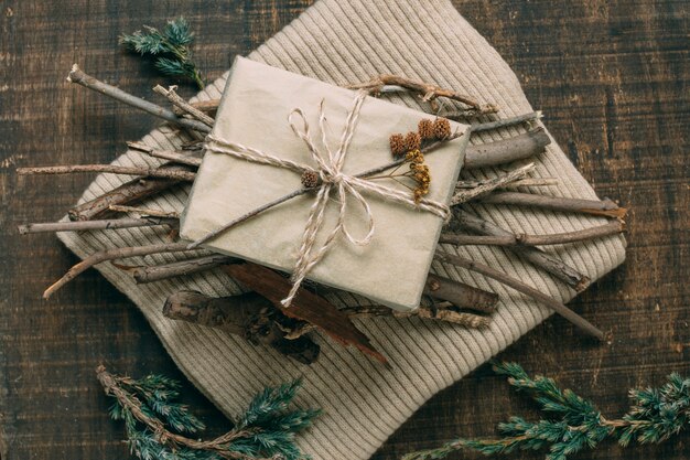 Above view decoration with gift and twigs on sweater