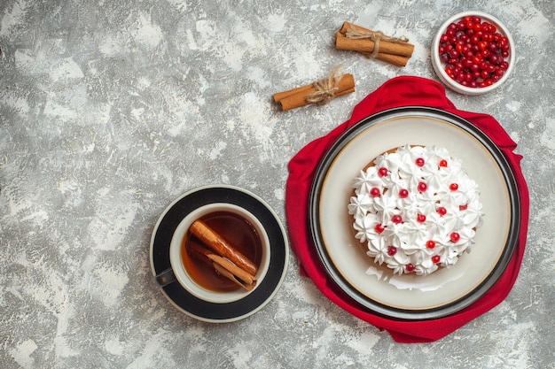 Above view of delicious creamy cake decorated with fruits on a red cloth