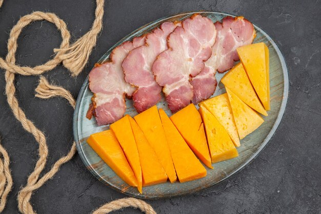 Above view of delicious snacks on a blue plate and rope on a black plate