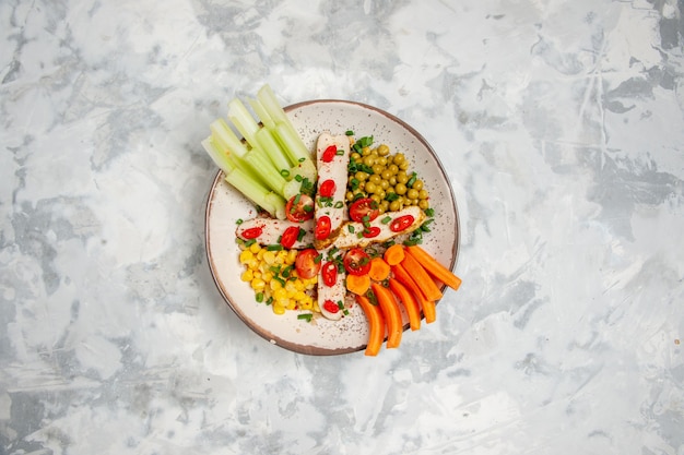 Above view of delicious vegan salad on a plate on white surface with free space