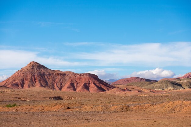 View of desert mountains with an arid landscape against a cloudy blue sky
