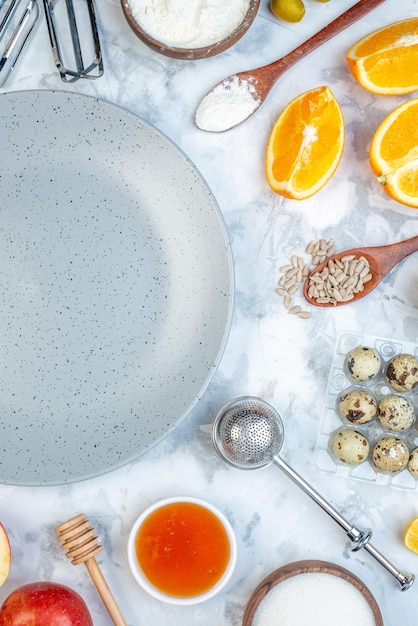 Above view of empty gray plate and ingredients for the healthy food set on ice table