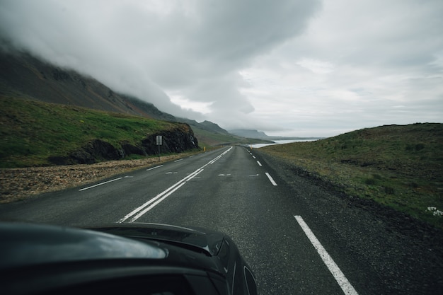 Вид на пустую исландскую дорогу изнутри автомобиля