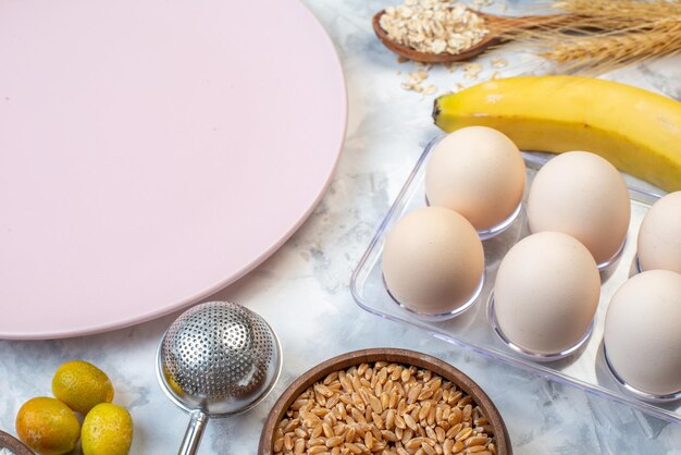 Above view of empty white plate and fresh fruits eggs spikes on two-toned background