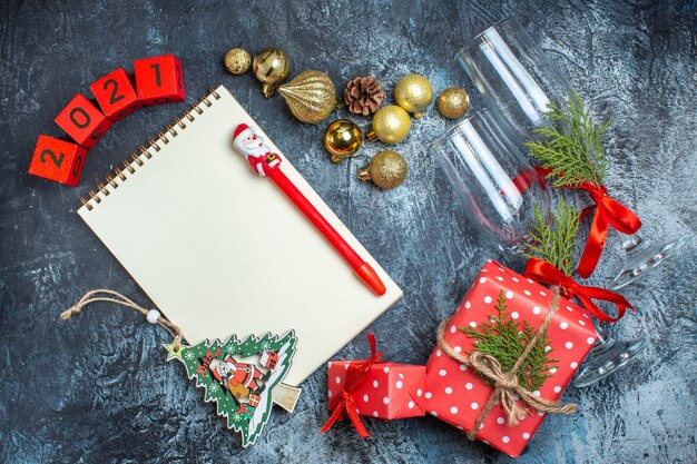 어두운 테이블에 떨어진 유리 잔과 칼 붙이 세트 장식 액세서리 선물 상자 및 크리스마스 양말 번호의 보기