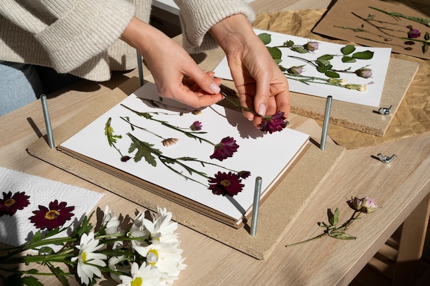 Free photo view of female artisan pressing flowers