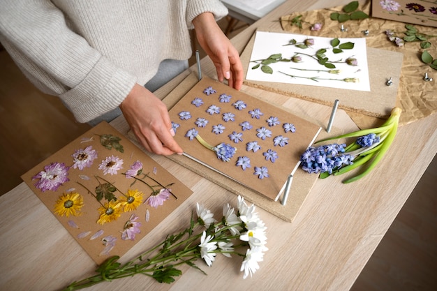 Free photo view of female artisan pressing flowers