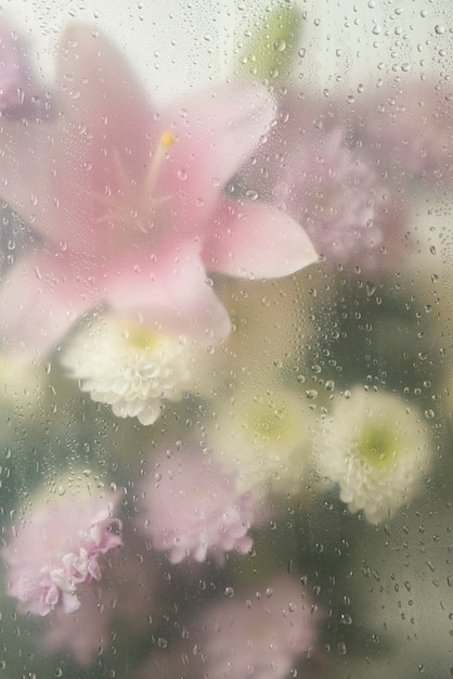 凝縮されたガラスを通しての花の眺め