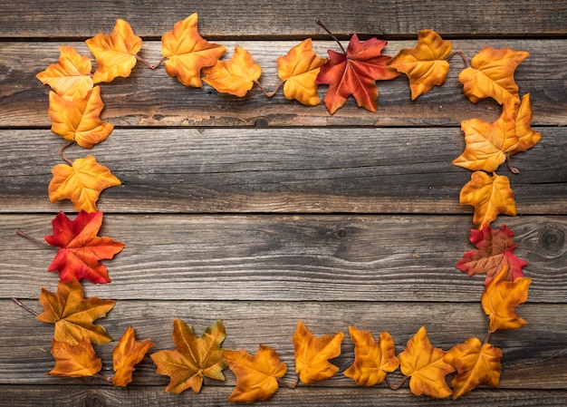 Above view frame with colourful leaves on wooden table