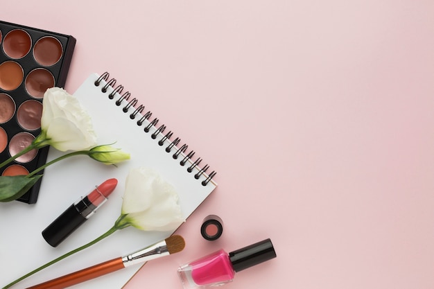 Above view frame with make-up products and flowers